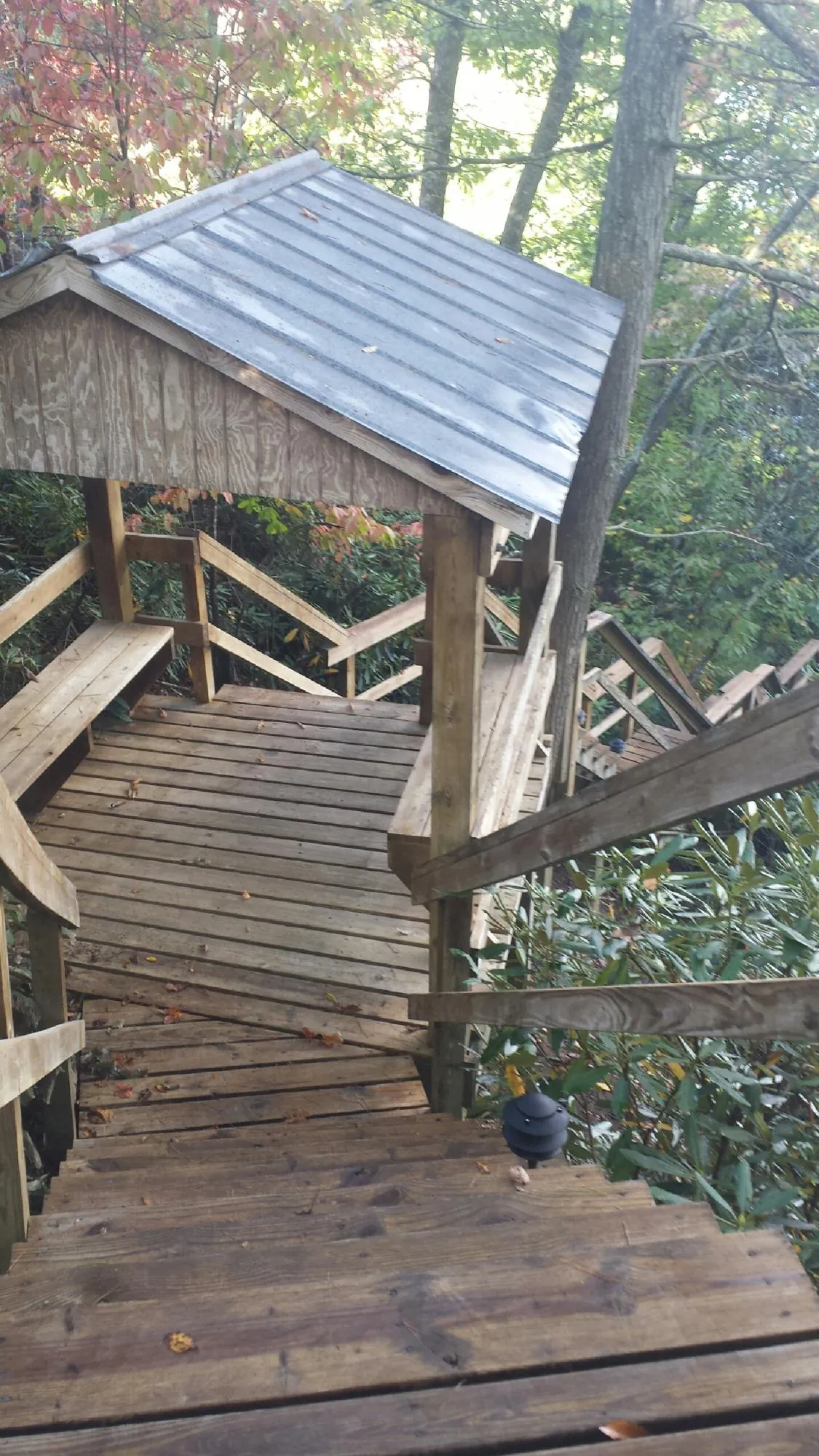 Metal roofed shelter over wooden steps on a wooded walkway — Skylight Repair & Installation work by our crew in New Bedford